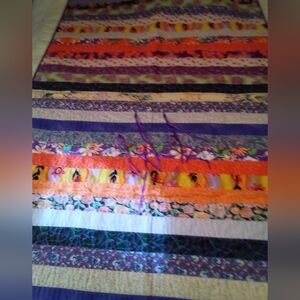 Colorful Striped Quilt with purple ties They can be removed or toys tied to them